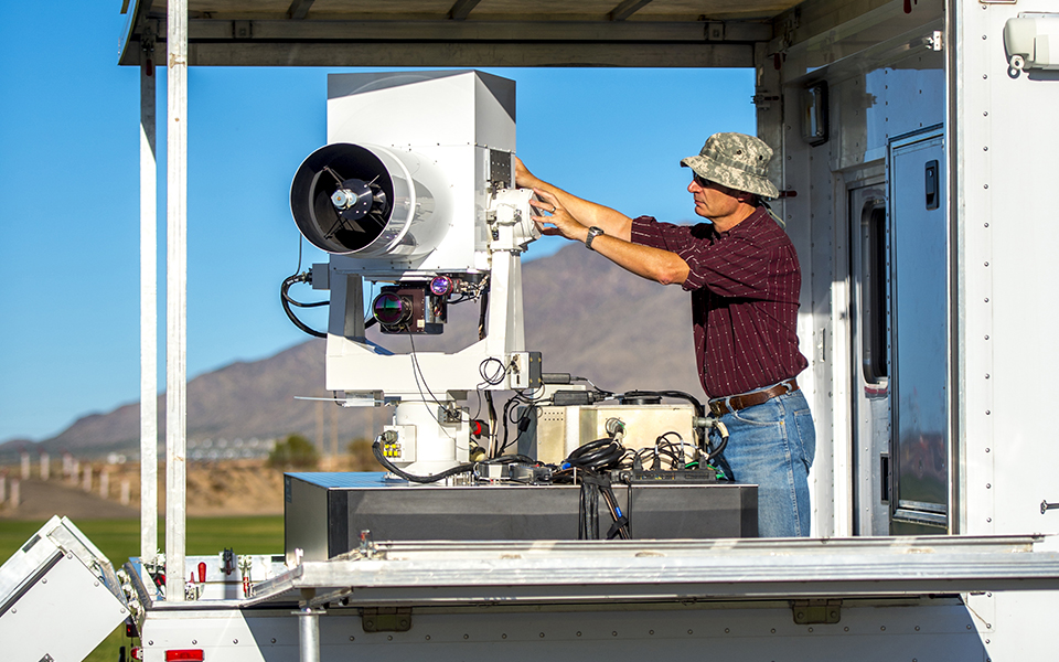 A Boeing employee configures a precision EO/IR pointing and tracking system 